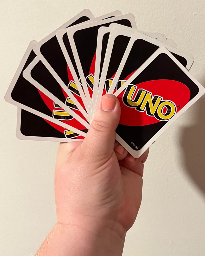 Abby's hand fanning out black and red Uno cards.