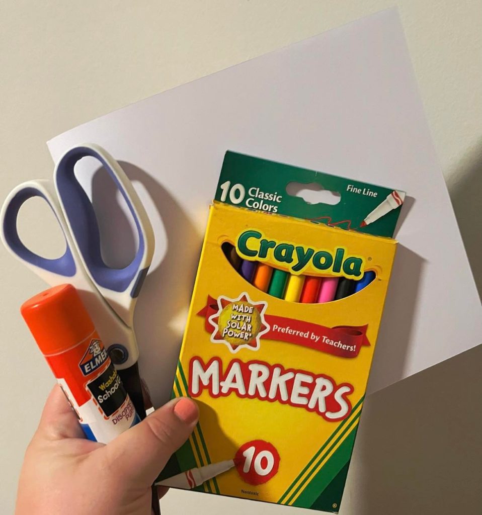 White paper, crayola pack of 10 skinny markers, a glue stick, and scissors.