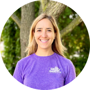 Sarah C Abbey stands for a head shot outside in front of a tree